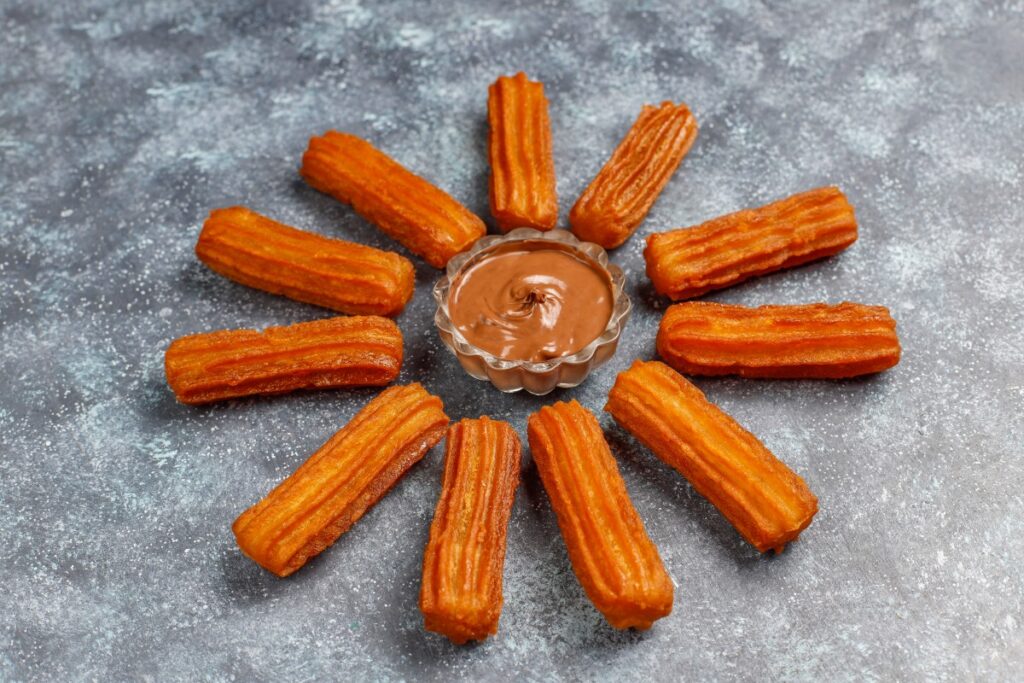 Golden traditional churros arranged around a bowl of chocolate sauce beside “Lacinia nunc curabitur tortor pellentesque nibh.”